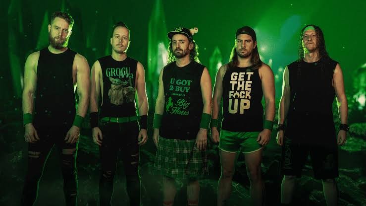 Promotional photo of Alestorm featuring the band standing together against a green-lit backdrop