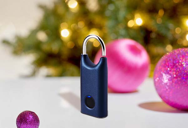 A Blue Lexon Nomaday Smart Padlock standing beside Christmas baubles