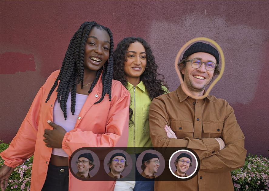 Three smiling people are posing outdoors in front of a reddish-brown wall. The person on the right has a yellow outline around their head and is highlighted in a selection bar at the bottom with four different headshots. Three smiling people are posing outdoors in front of a reddish-brown wall. The person on the right has a yellow outline around their head and is highlighted in a selection bar at the bottom with four different headshots.