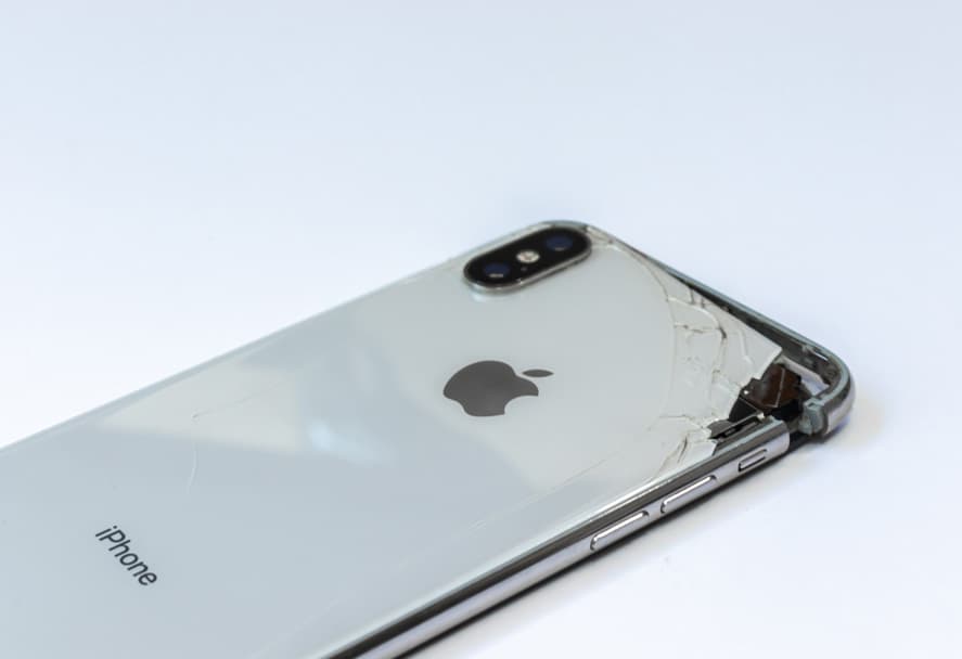 An iPhone X with a severely cracked clear case on its back, revealing the Apple logo and "iPhone" text. An iPhone X with a severely cracked clear case on its back, revealing the Apple logo and "iPhone" text.