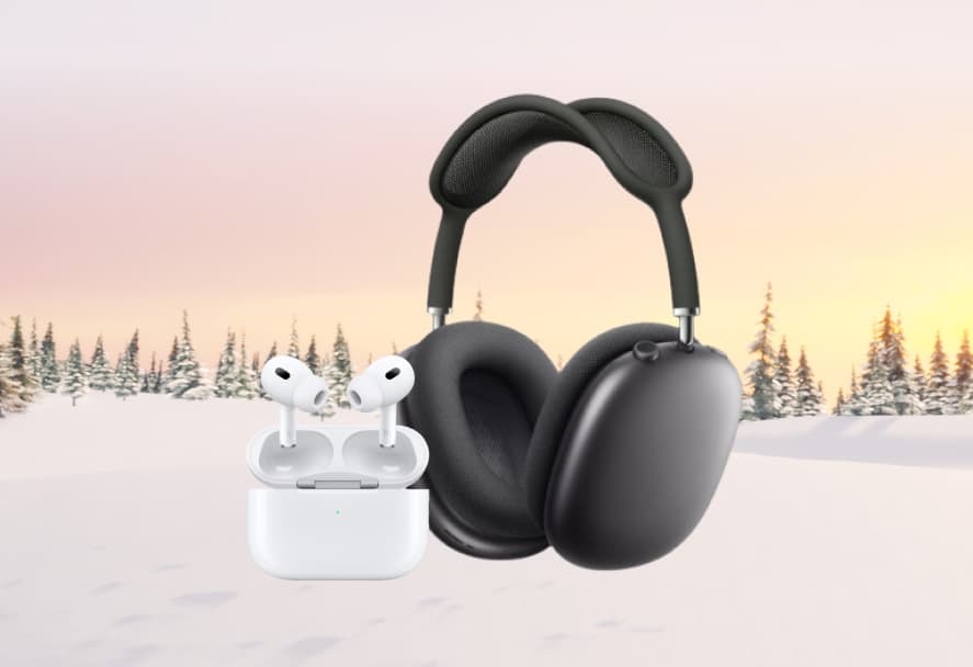 Black AirPod headphones beside a white pair of AirPods earbuds with charger on a snowy mountain backdrop