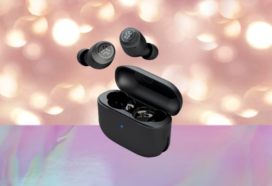 Black JLab wireless earbuds and charging case on a sparkly backdrop