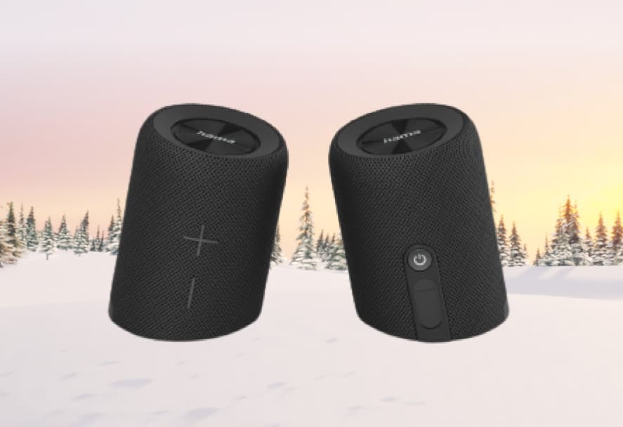 A black music speaker that can split into two by HAMA on a snowy mountain backdrop
