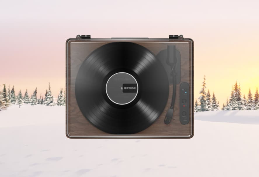 A brown ION record player on a snowy mountain backdrop