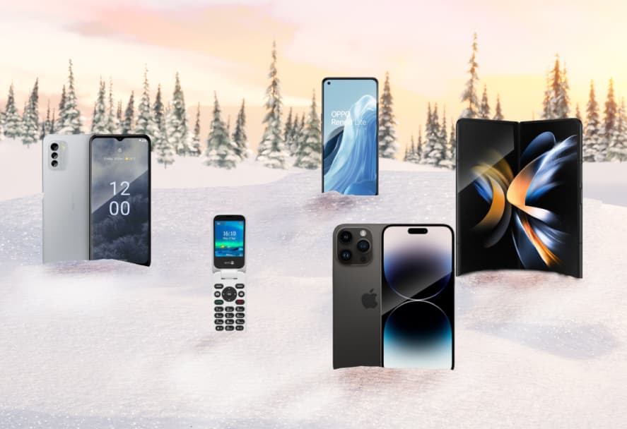 A selection of smartphones and flip phones on a snowy mountain backdrop