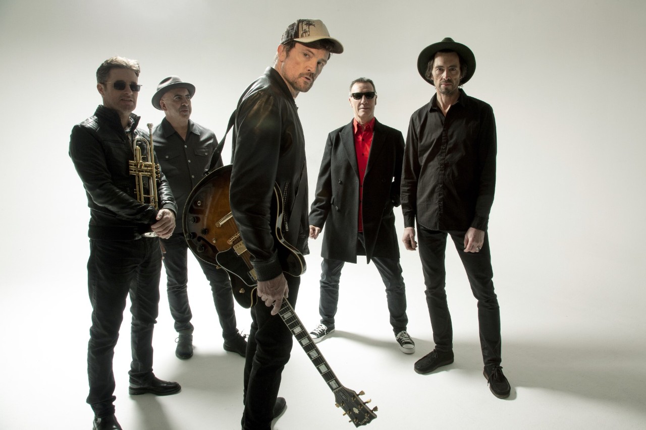 The Stunning posing for a promotional photo with guitars and a trumpet.