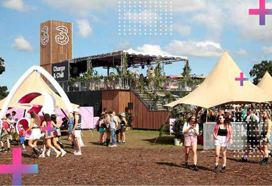 A bustling Electric Picnic festival scene features tents, a Three "Charge & Chill" building, and numerous attendees under a partly cloudy sky with digital cross overlays.