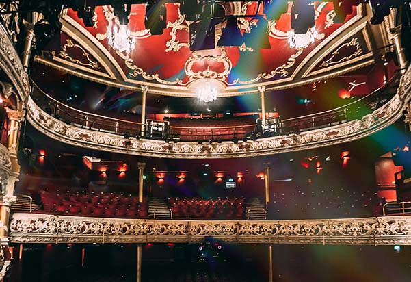 Interior of the 3Olympia showcasing it's regal decor of golden stall barriers and red painted walls