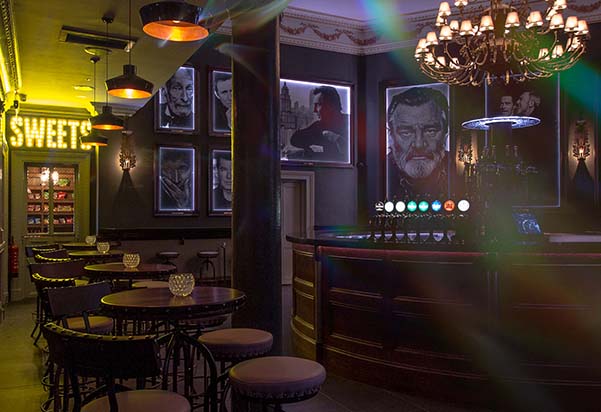 Inside 3Olympia bar with iconic murals of artists and hanging chandeliers