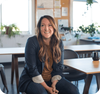 Person sitting in a brightly lit classroom filled with desks and chairs. Person sitting in a brightly lit classroom filled with desks and chairs.