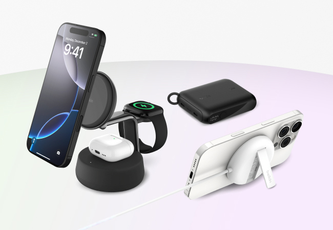A multi-product display of Belkin charging accessories features a 3-in-1 wireless charging stand with an iPhone, Apple Watch, and AirPods charging, alongside a black portable power bank, and a white iPhone with a MagSafe charger and kickstand.