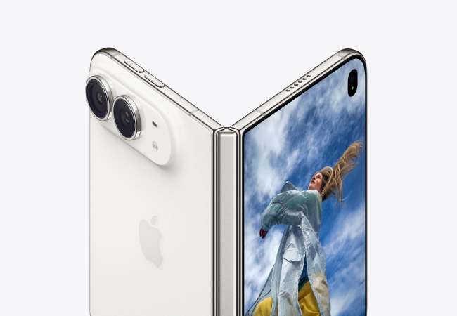 An iPhone Duo partially folded in tent mode, showing its silver-white back cover with dual cameras on the left and an active screen showing a person looking up at a blue sky on the right.