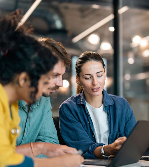 Three people collaborating over a laptop, sharing ideas while looking at the computer's display.