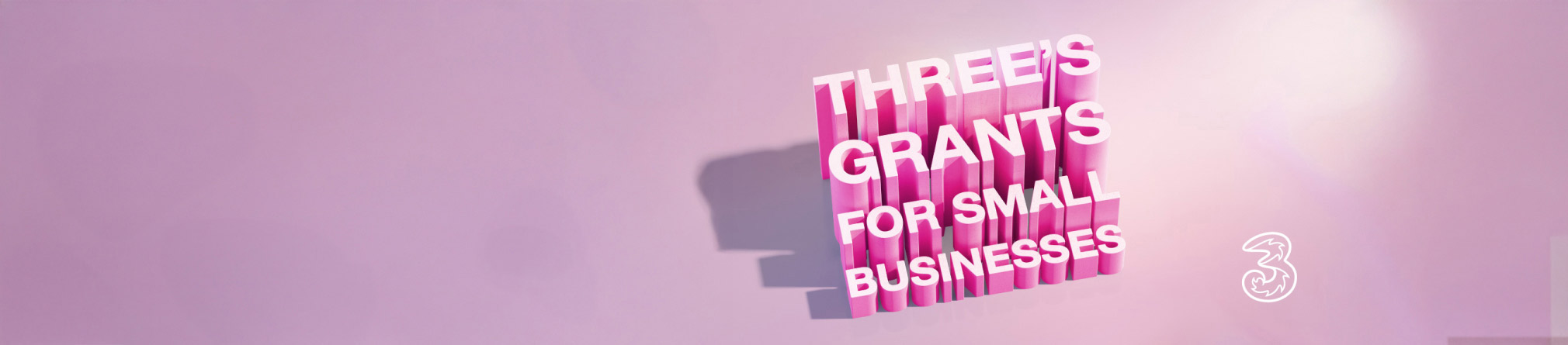 Three's Grants for Small Businesses is displayed in large, pink, 3D block letters against a solid pink background. The "3" logo is in the bottom right corner.