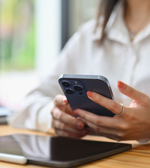 Mobile phone being held by a person sitting at a desk