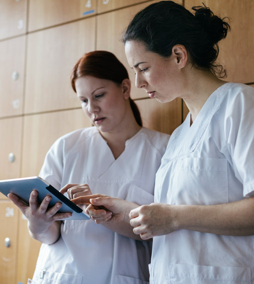 Two uniformed staff checking a tablet