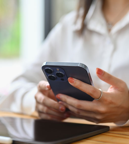 Mobile phone being held by a person sitting at a desk