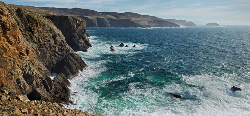 Panoramic image of the arronmore coastline, highlighting the stunning cliffs and vibrant ocean waves.