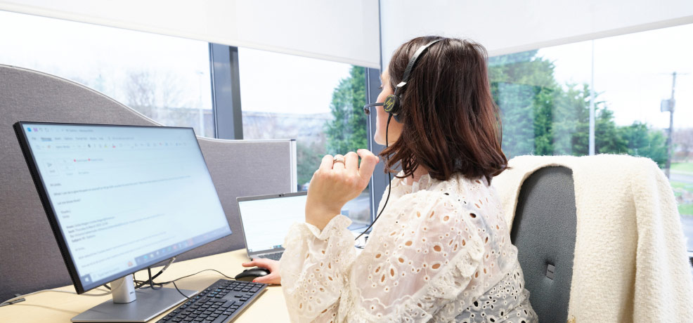 A person with a headset on, appearing engaged in a virtual meeting or call.