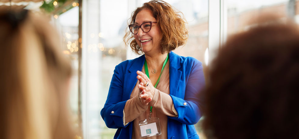Person wearing a lanyard speaking in a group