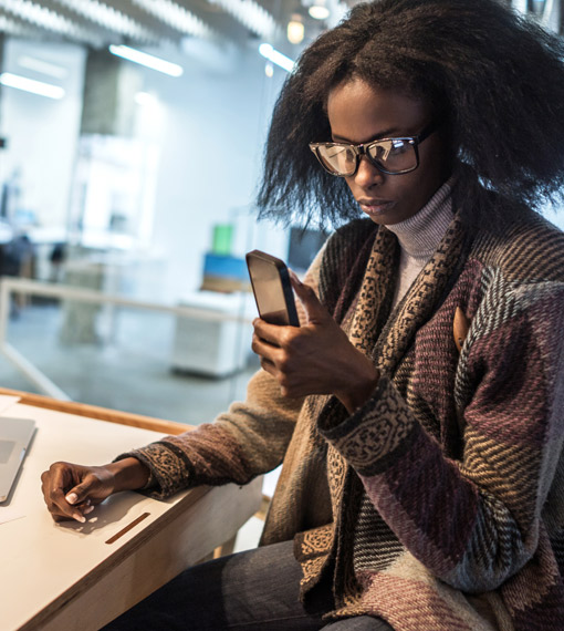 Person sitting at a desk looking at a phone