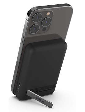 Black Belkin wireless portable charger with stand extended and a phone charging on it.
