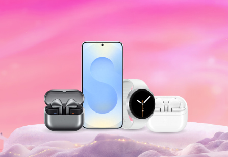 A Samsung Galaxy S25, Samsung smartwatch, dark charging case with earbuds, and white charging case with earbuds displayed together on a snowy, pink background.