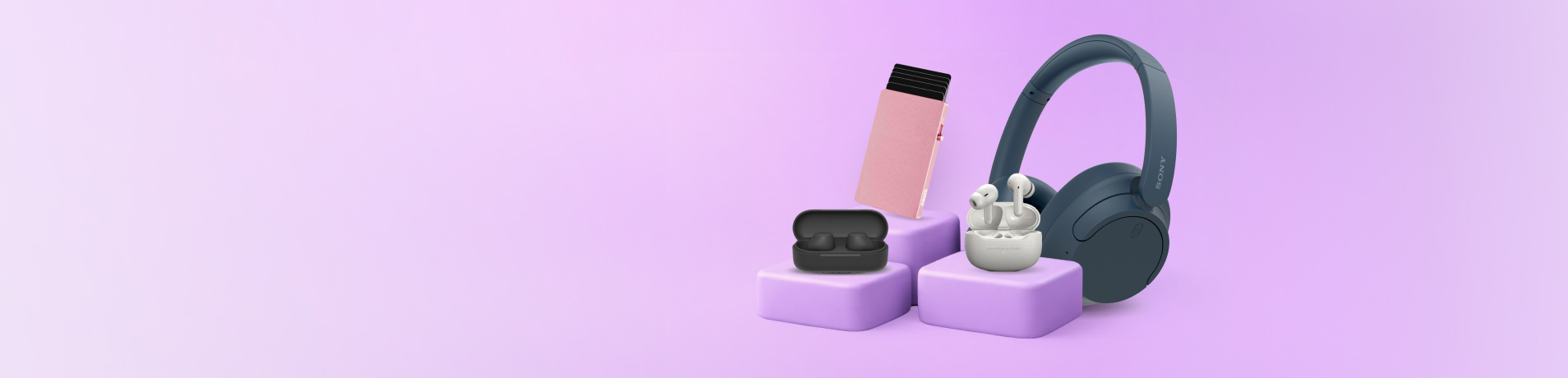 A collection of tech accessories including navy headphones, white earbuds, a black earbud case, and a pink card protector, all displayed on purple tiered platforms.