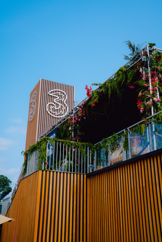Three Ireland-branded Electric Picnic stage structure decorated with greenery and flowers.