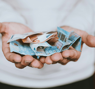 A close up shot of a person with both palms open with various euro notes in them