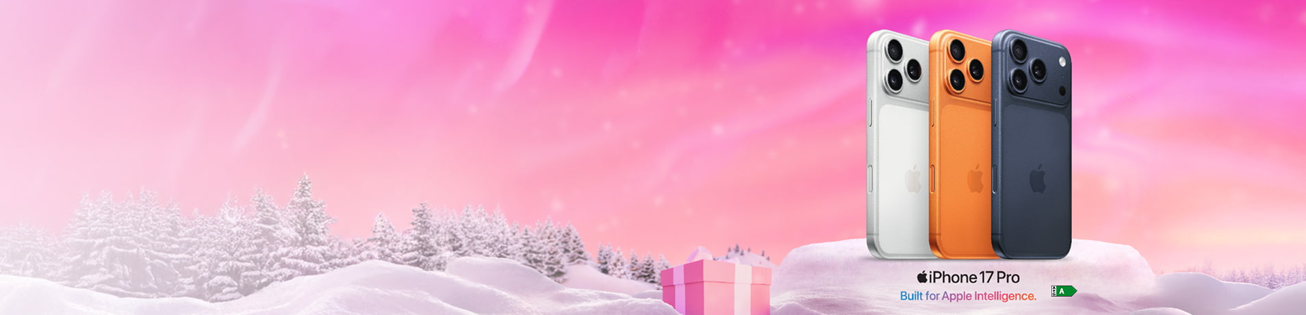 Three different colored iPhone 17 Pro models (white, orange, and blue) standing on a snowy platform against a pink, wintery background with snow-covered trees.